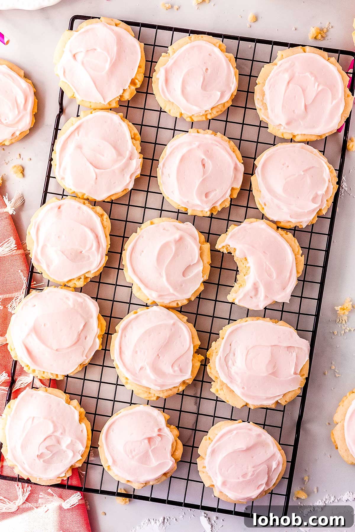 15 Swig sugar cookies on a wire rack with a bite taken out of one of the cookies.
