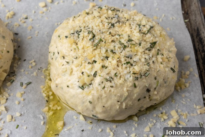 Rosemary Parmesan Loaf with Crispy Herb Crust 5 Unbaked Rosemary Parmesan Garlic Bread on a parchment lined sheet pan